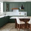 an image of a kitchen setting with green cabinets and white counter tops, along with four stools