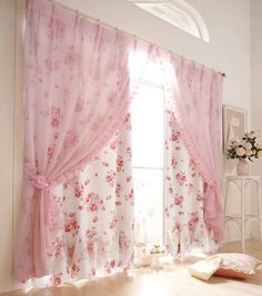 a bedroom with floral curtains and pink bedding