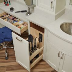 a bathroom sink and counter with an open drawer in it's center, next to a mirror