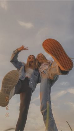 two young women are posing with their feet in the air