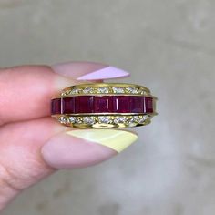 A vintage ruby and diamond ring, featuring a row of eight carré cut rubies. The total ruby weight is approximately 0.80 carats. Eight round brilliant cut diamonds are set in horizontal rows above and below the rubies. The total approximate weight of the diamonds is 0.96 carats. This ring was handcrafted in 18k yellow gold circa the 1970’s.


The width of this ring is approximately 5.26mm.
This ring is currently sized at 5.75 and can be resized at no extra cost.
Ready to Make It Yours? Reserve it Luxury Ruby Ring With Vvs Clarity And Emerald Cut, Red Ruby Ring With Vvs Clarity And Baguette Cut, Luxury Emerald Cut Ruby Ring With Vvs Clarity, Ruby Diamond Ring With Vvs Clarity And Baguette Cut, Luxury Ruby Ring Channel Set For Anniversary, Ruby Ring With Channel Set Diamonds In Yellow Gold, Yellow Gold Ruby Ring With Channel Set Diamonds, Luxury Diamond Channel Set Ruby Ring, Red Ruby Ring With Channel Set Diamonds