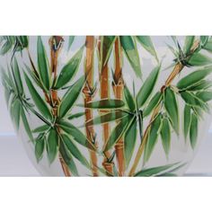 a vase with bamboo leaves painted on it's sides and bottom, in front of a white background