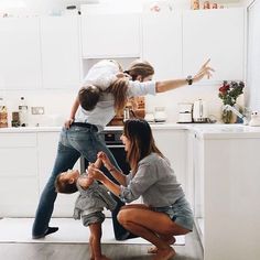 three people in a kitchen with one holding the other's hand and pointing at something