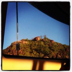 the view from inside a vehicle looking at mountains and trees