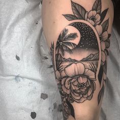 a woman's leg with a half moon and flowers on it