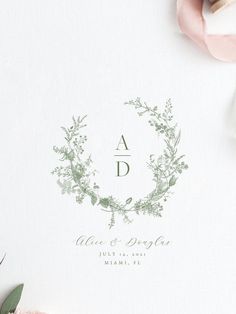 the wedding stationery is laid out with flowers and greenery on top of it