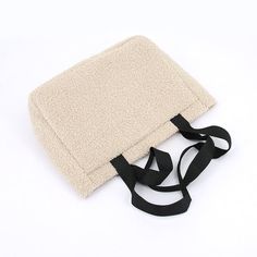 a white blanket with black straps laying on top of it