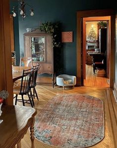 a living room filled with furniture and a rug on top of a hard wood floor