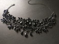 a very pretty black and silver necklace on a table