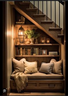 a set of stairs with bookshelves and pillows on the bench in front of it