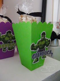 two purple and green popcorn boxes with the hulk logo on them sitting on a table