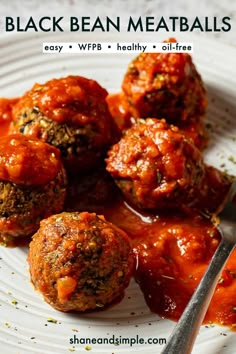 some meatballs are sitting on a plate with sauce