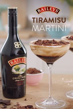 two glasses filled with chocolate dessert next to a bottle of bailey's trirami martini