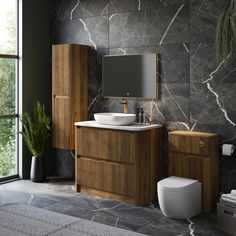 a bathroom with a toilet, sink and mirror next to a plant in a vase