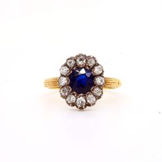 Victorian sapphire and diamond cluster ring mounted in silver and 18ct gold. English. Circa 1880. The central round cushion shaped Burmese sapphire surrounded by an old cut round diamond border. Total sapphire weight approximately 1.20cts. Ttoal diamond weight approximately 0.80cts Antique Sapphire Ring With 17 Jewels, Victorian Sapphire Ring With Oval Brilliant Cut, Sapphire Cluster Ring With 17 Jewels, Victorian Sapphire Ring With Diamond Oval Shape, Antique Sapphire Diamond Ring With Rose Cut, Victorian Oval Sapphire Ring With Diamond, Antique Oval Sapphire Ring With Single Cut Diamonds, Antique Blue Diamond Ring With Rose Cut, Victorian Oval Diamond Ring With Halo Setting