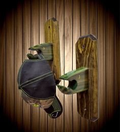 a wooden wall with two metal hooks and a hat hanging from it's side