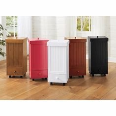 four different colored trash cans sitting on top of a hard wood floor