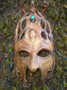 "This leather mask is made of vegetable tanned leather and is slightly flexible , light weight and very comfortable to wear. The over all measurement is 14\" It has been carefully etched to produce a realistic tree-like texture. The crown features a small leather sculpted face that peers out from an opening in the forehead. A turquoise stone is embedded at the top as an eye catching accent." Shaman Mask, Sculpted Face, Costume Masks, Leather Mask, Costume Mask, Man Photo, Green Man, Vegetable Tanned Leather, The Crown