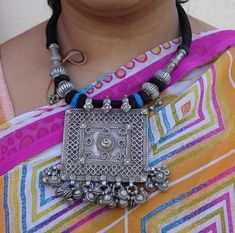 "Antique Tribal old silver necklace from Rajasthan India. These necklaces worn by Banjara tribal people from Rajasthan Desert. One big size heavy square old silver pendant re strung together strongly with four old silver beads ,end finish with loop and silver ball. Attached noisy bells in all the bottom loops. The middle big pendant called (silver house amulet) a symbol of family unity represented by walled-in rectangle, the amulet uses stamped floral units to cover joins. See similar sample in Rajasthan Desert, Family Unity, Big Pendant, Silver Necklace Pendant, Traditional Jewellery, Jewellery Inspiration, Rajasthan India, Boho Vintage, Traditional Jewelry