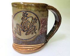 a ceramic coffee mug with an intricate design on it's side and inside rim