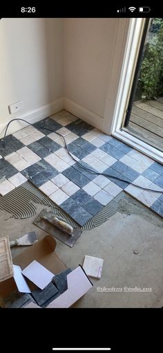 a room that is being remodeled with tile on the floor and tools laying around it