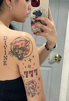 a woman taking a selfie with her cell phone and tattoos on her back shoulder