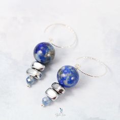 These elegant Lapis Lazuli bead stones dangle drop earrings feature a beautiful deep blue 12 mm Lapis Lazuli beads dangle drop and two painted silver Hematite stone beads, a faceted blue Kyanite tiny bead drop at the end. The beads are on solid 925 sterling silver eye pin, hooked on a diamond cut texture 925 sterling silver ear wire. Add these elegant Lapis Lazuli, Hematite and Kyanite beads dangle drop earrings to your everyday fine jewelry collection or as a gift for your loved one. Materials: 925 sterling silver, Lapis Lazuli, UV hematite, kyaniteDimensions: 1.84 x 0.46 in Jewelry Care: See more information about how to care for your jewelry here. Shipping Policy: Orders will be shipped within 1-3 business days. Economy shipping will take 7-14 days to arrive and standard shipping is 1- Agate Earrings With Natural Stones In Round Beads Shape, Adjustable Gemstone Bead Drop Earrings, Lapis Lazuli Jewelry With Faceted Beads, Adjustable Metal Earrings With Faceted Beads, Spiritual Gemstone Bead Drop Earrings, Elegant Agate Gemstone Bead Earrings, Healing Lapis Lazuli Jewelry With Faceted Beads, Agate Gemstone Bead Dangle Earrings, Blue Gemstone Bead Drop Earrings