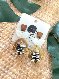 Introducing our stunning Geometric Dangle Earrings – a fusion of earthy elegance and bohemian flair that will add a touch of artistry to your ensemble! 🌿✨Crafted with creativity and care, these earrings feature mesmerizing mussel shell half moon connectors, exuding natural beauty and coastal charm. Paired with brass arches, wood posts, 5mm wood beads, and Kenyan polka dot bone saucer beads, these earrings boast a captivating blend of textures and tones, from warm browns and rich golds to crisp Adjustable Earthy Dangle Earrings, Bohemian Drop Earrings With Unique Variations, Bohemian Brown Pierced Earrings, Earthy Dangle Earrings With Ear Wire, Unique Brown Teardrop Earrings, Gold Bohemian Earrings With Unique Variations, Artsy Brass Drop Earrings, Brown Brass Drop Earrings, Earthy Handmade Dangle Earrings