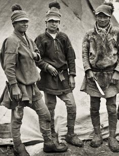 three men standing next to each other in front of a tent