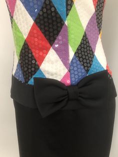 This is a strapless dress from Jenna Benjamin, USA. The bodice of the dress is a colorful harlequin pattern that is completely covered in clear sequins, giving it a lovely shine. The skirt is solid black and the low waist is accented with a bow. The dress zips in the back and is boned in the bodice. Size tag 6. Check measurements carefully, no stretch. Measurements taken with dress laying flat and doubled where appropriate. In order to determine fit we recommend comparing measurements with an it Elegant Multicolor Strapless Evening Dress, Elegant Fitted Multicolor Strapless Dress, Multicolor Fitted Strapless Dress, Multicolor Strapless Dress For Party Season, Multicolor Fitted Strapless Dress For Cocktail, Multicolor Fitted Strapless Cocktail Dress, Fitted Multicolor Strapless Dress For Cocktail, Glamorous Multicolor Strapless Dress, Low Waisted Dress