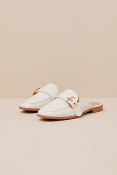 Upgrade your everyday flats with a chic new option like the Lulus Marquete Bone Buckle Mule Slides! These too-cute mules have a smooth, faux leather construction that shapes an almond toe upper and an adjustable strap with a gold buckle and matching grommets. Classic notched collar leads to a slide-on design for effortless styling. 0. 75" rubber heel. Cushioned insole. Rubber sole has nonskid markings. Man made materials. Imported. Lulus | Marquete Bone Buckle Mule Slides | Size 10. Spring Faux Leather Closed Toe Slip-ons, Spring Flat Mules With Buckle Closure, Chic Synthetic Flat Slip-ons, Flat Mules With Buckle Closure For Work, Chic Beige Slip-ons For Fall, Summer Slip-on Loafers With Buckle Closure, Chic White Mules With Buckle Closure, Chic Cream Slip-on Mules, Synthetic Flats For Summer Office Wear