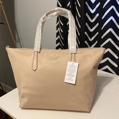 Brand New With Tags Attached. Kate Spade Large Tote. Warm Beige Color. With Leather Straps. Super Sleek And Cute Bag. Measurements: 17.32” D 11’h X 12’w Handle Drop 11.0” Top Zip Closure Interior: Back Zip & Front Slip Pockets Material: Recycled Nylon With Leather Straps Warm Beige, Bag Measurements, Large Tote Bag, Large Tote, Cute Bag, Beige Color, Womens Tote Bags, Leather Straps, Kate Spade