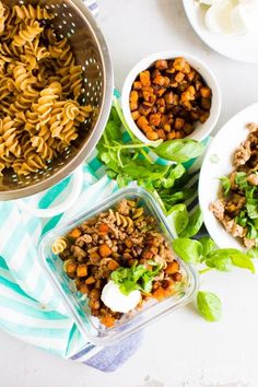 three bowls filled with different types of food on top of a blue and white towel