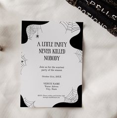 a little party never killed nobody card on a bed with spider webs and black lace