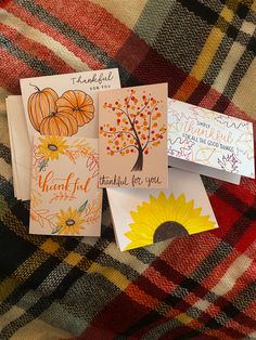 four thanksgiving cards laid out on a plaid blanket