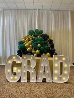 a large balloon sculpture with the word grad spelled out in front of it