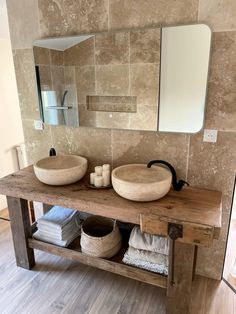 a bathroom with two sinks and a mirror on the wall next to each other in front of a wooden bench