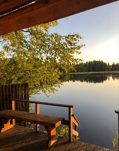 a bench sitting on top of a wooden deck next to a lake