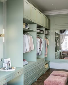 a walk in closet filled with lots of drawers and dressing room furniture next to a window