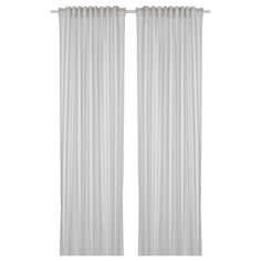 two white curtains hanging on the side of a window with pleated drapes