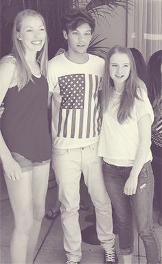 three young people posing for a photo in front of an american flag t - shirt