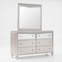 a white dresser with a mirror on top and drawers below it, against a white background