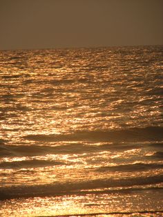 the sun shines on the water as it reflects in the ocean waves at sunset