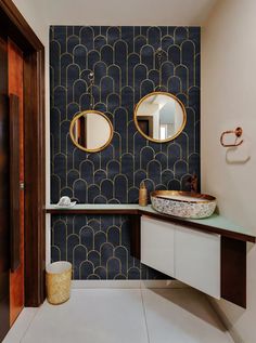 a bathroom with two circular mirrors on the wall and a sink in front of it