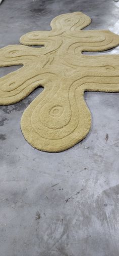 a large yellow rug on the ground with an intricately shaped design in the middle