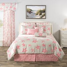 a bed with pink and white bedspreads in a bedroom