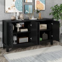 a living room with two black cabinets and pictures on the wall above it, along with a rug