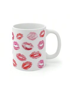 a white mug with red and pink lipstick on it