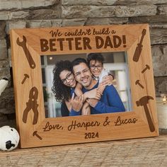 a wooden frame with an image of two people holding each other and the words, we couldn't build a better dad