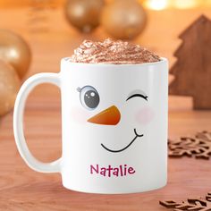 a coffee mug with a snowman face on it and the words nattie written in pink